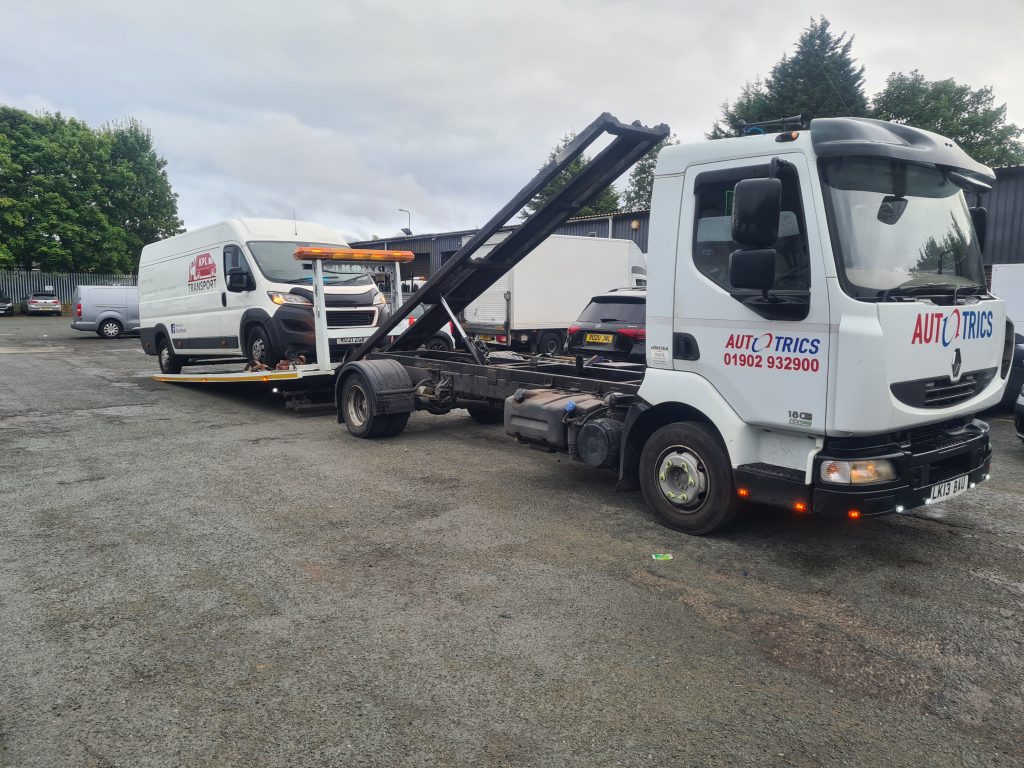 Vehicle recovery truck loading a commercial van at a depot in Wolverhampton, West Midlands